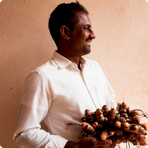 Prabhu Kasereni, the Pragati Turmeric farm partner holding freshly plucked turmeric roots.