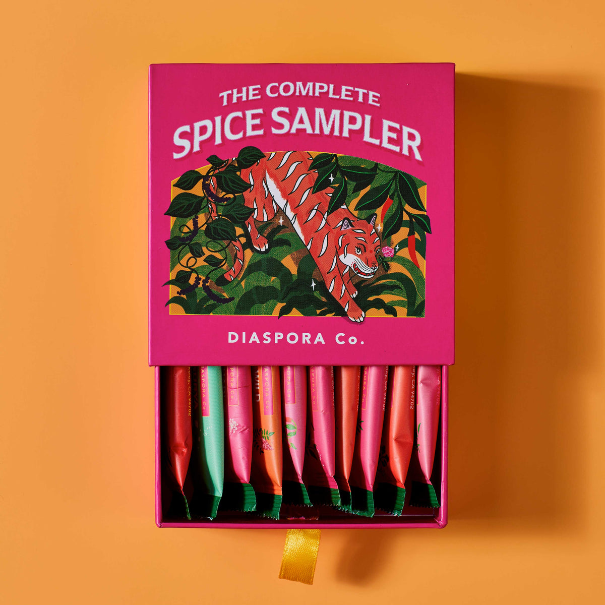 Spice sampler box with tiger illustration on a bright orange background