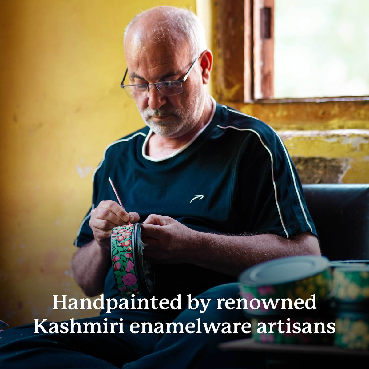 Man working on handpainted enamelware with text about renowned Kashmiri artisans