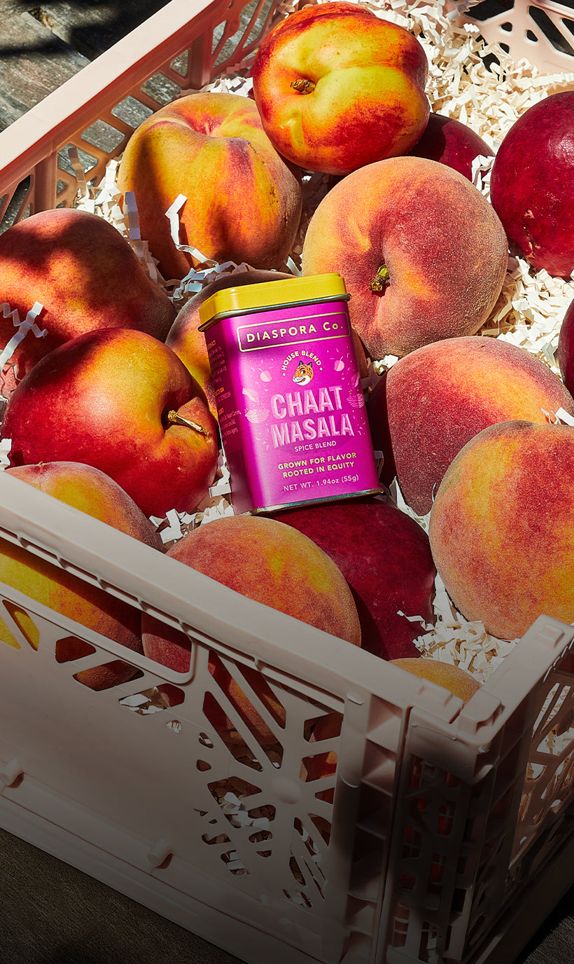 Chaat Masala tin kept against a background of fresh fruit